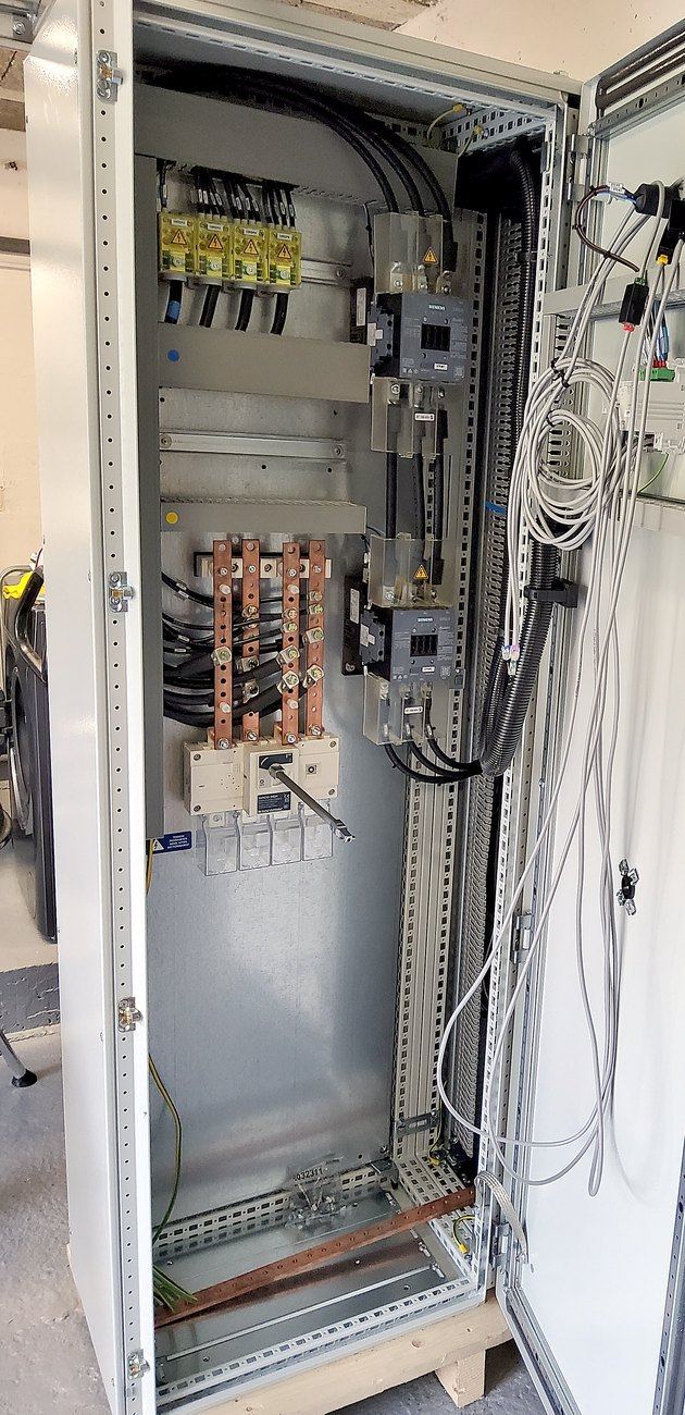 Cellule d'arrivée en cours de fabrication : jeu de barres cuivre, interrupteur-sectionneur et départs protégés.
